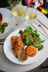 Grilled meat with vegetables and two glasses of white wine
