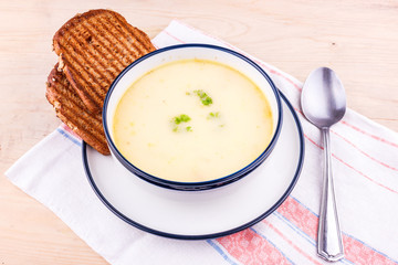 Cheese soup in a white plate with toasted bread