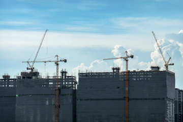 Building crane and buildings under construction and cloudy sky