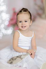 Fototapeta premium Beautiful small girl in white dress posing indoor.