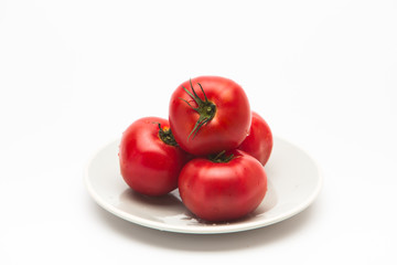  Red tomatoes in a plate on white background 