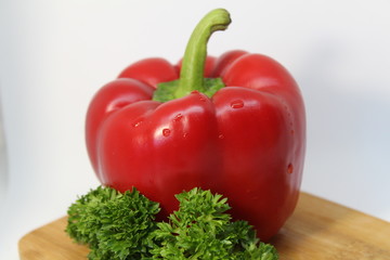 red pepper with greenery n the wooden board