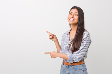 Young pretty arab woman excited pointing with forefingers away.