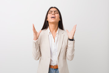 Young business arab woman isolated against a white background screaming to the sky, looking up,...