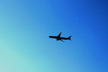 Flying plane in the blue sky with clouds