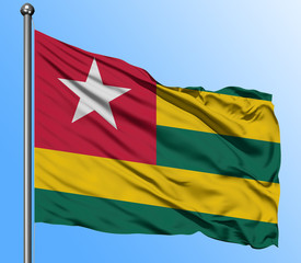 Togo flag waving in the deep blue sky background. Isolated national flag. Macro view shot.