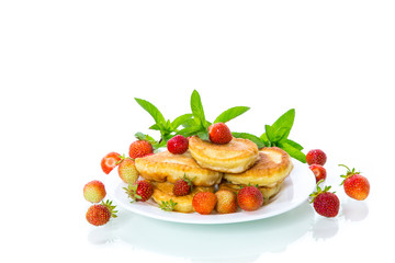 fried sweet pancakes with ripe strawberries in a plate