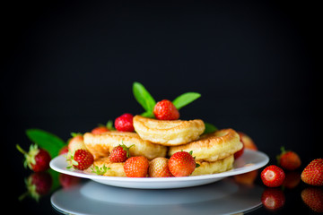 fried sweet pancakes with ripe strawberries in a plate