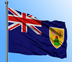 Turks And Caicos Islands flag waving in the deep blue sky background. Isolated national flag. Macro view shot.