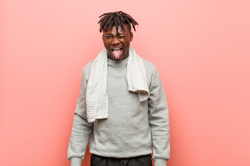 Young fitness african black man funny and friendly sticking out him tongue.