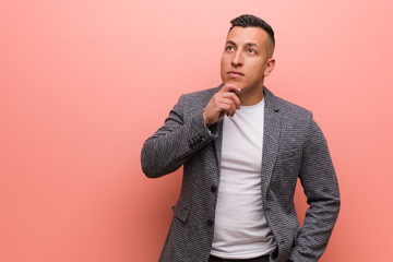 Young elegant latin man doubting and confused