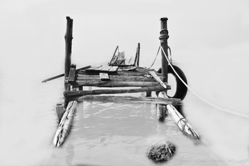 A small wooden dock for fishing boats at Acheloos river in a minimal version mouth in black and white