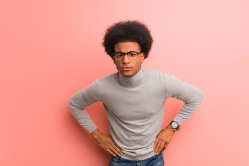 Young african american man over a pink wall scolding someone very angry