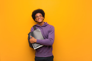 Young african american student man smiling confident and crossing arms, looking up