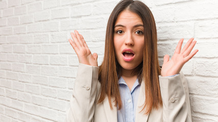 Young business woman surprised and shocked