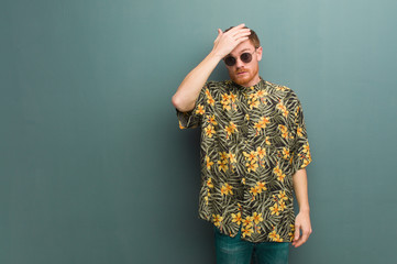 Young redhead man wearing exotic summer clothes worried and overwhelmed