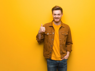 Young redhead man smiling and raising thumb up