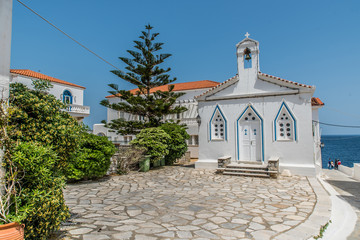 Traditional alleys with a small orthodox church at the Chora of Andros on a beautiful day