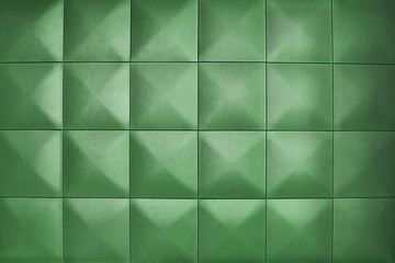 Fototapeta na wymiar Unusual, beautiful and modern background. Rhombic pale green color wall of big squares. Background consists of large pale green squares.