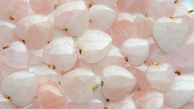 Semi-precious stone hearts of rose quartz are rotating in a clockwise direction top view