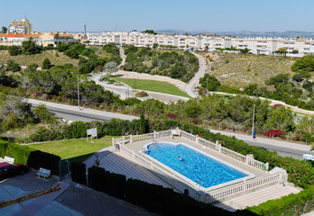 View from above unrecognizable person swimming in private pool across the road picturesque popular place for relaxation Aromatic Park, Torrevieja, Province of Alicante. Costa Blanca. Spain
