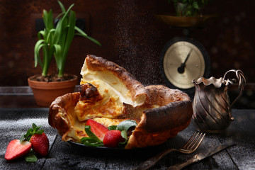 Appetizing pastries in the form of a large pancake with strawberries on the background of vintage scales. Photos in the interior. Still life concept.