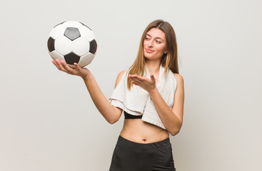 Young fitness russian woman holding something with hand. Holding a soccer ball.