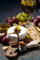 Camembert cheese, snacks and glasses of wine, vertical, closeup