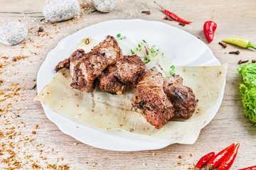 Close up view on served cooked on the grill lamb. shashlik or barbecue meat on pita. Shish kebab, traditional georgian cuisine food. Copy space for design