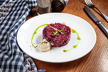 Close up view on fresh salad from beets and garlic mousse. Modern cuisine. Traditional vinaigrette served on wooden background. Copy space for design. Picture for menu or recipe. Healthy food, dieting