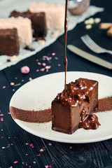 Close up view on fresh chocolate dessert pouring hot chocolate on a dark background. Flying food. Freeze motion. Copy space for design.