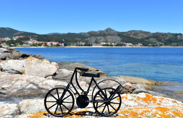 Fototapeta na wymiar Coast with black iron bicycle. Galicia, Spain, sunny day.