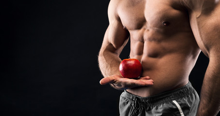 Unrecognizable man holding red apple in his muscular hand