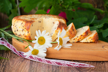 sliced cheese with cumin on a wooden table. Celebration of a traditional holiday in Latvia Ligo in...