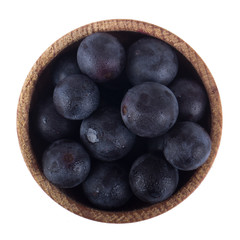 blue grapes in wooden cup isolated. top view