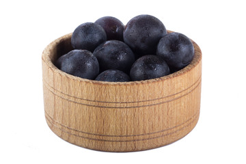 blue grapes in wooden cup isolated