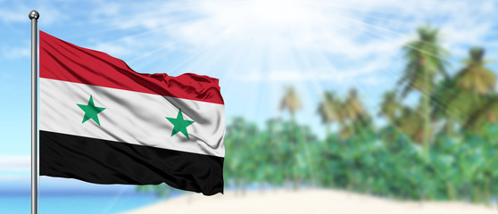 Waving Syria flag in the sunny blue sky with summer beach background. Vacation theme, holiday...