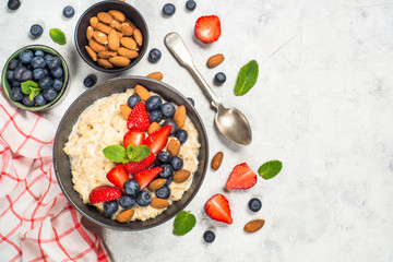 Oatmeal porridge with fresh berries and nuts top view. 