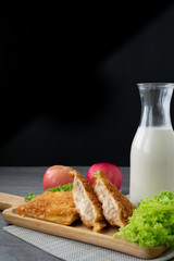 Deep fried sandwich stuffed tuna in wooden dish on table.