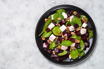 Fresh salad from spinach, beet and feta cheese with walnut.
