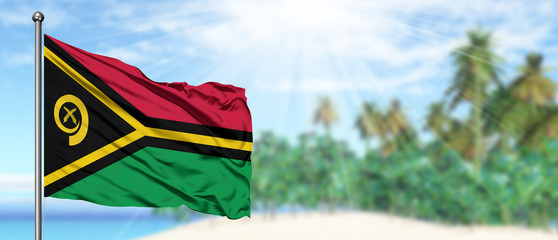 Waving Vanuatu flag in the sunny blue sky with summer beach background. Vacation theme, holiday concept.