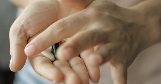 Close-up of Female Hands, Someone Pours a Bunch of Prescription Opiate Pills into the Hand. Concept of Health, Drugs, Contraception.