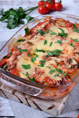 Roasted cabbage rolls with melted cheese in a glass baking dish. Russian cuisine meal