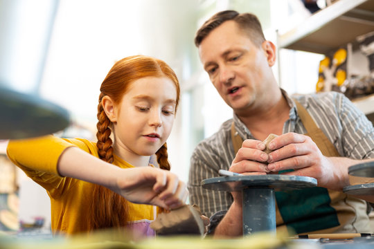 Girl feeling involved while working with clay in art school