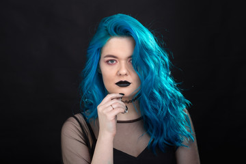Sryle and fashion concept - Close up portrait of woman with blue long hair over black background