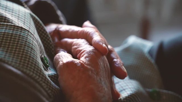 Retired old woman on a nursery home with shiver hands a&iexcl;covered with wrinkles. Take care of the elderly in the last phase of their life. Diseases like parkinson are treatable. 