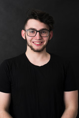 Obraz premium Studio shot of young handsome casual businessman against the black background.