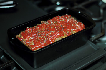 Homemade meatloaf baked in a cast iron loaf pan fresh out of the stove.