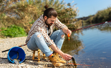 Positive fisherman holding catch freshwater fish in hands