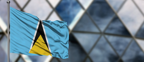 Saint Lucia flag waving in the wind against blurred modern building. Business concept. National cooperation theme.